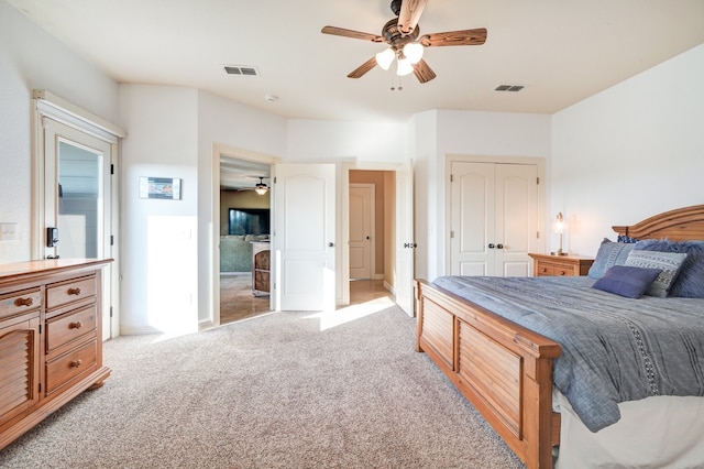 bedroom with a ceiling fan, a closet, visible vents, and light colored carpet