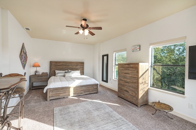 carpeted bedroom featuring baseboards, visible vents, and a ceiling fan