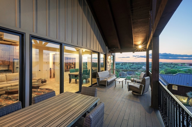 deck at dusk featuring outdoor dining area and outdoor lounge area