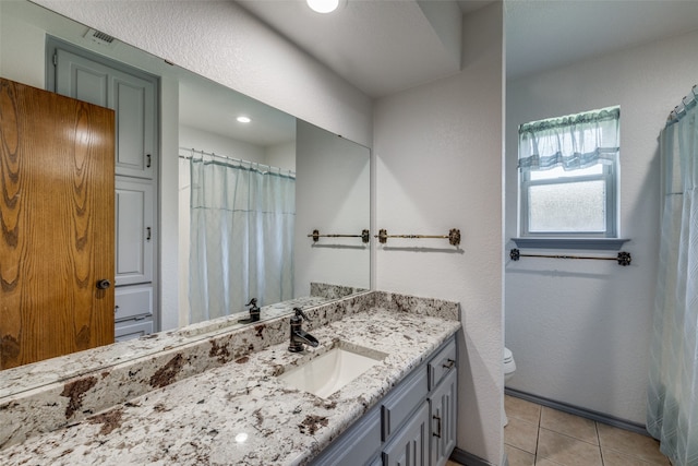 bathroom featuring tile patterned flooring, vanity, and toilet