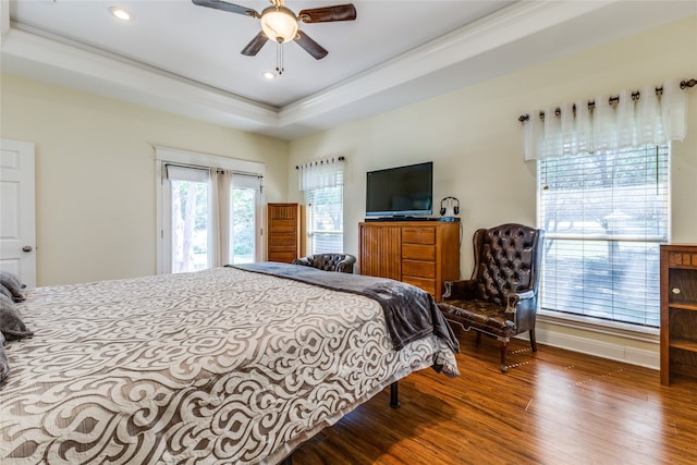 bedroom with a tray ceiling, ceiling fan, and wood-type flooring