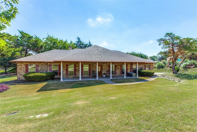 rear view of house featuring a lawn and a patio