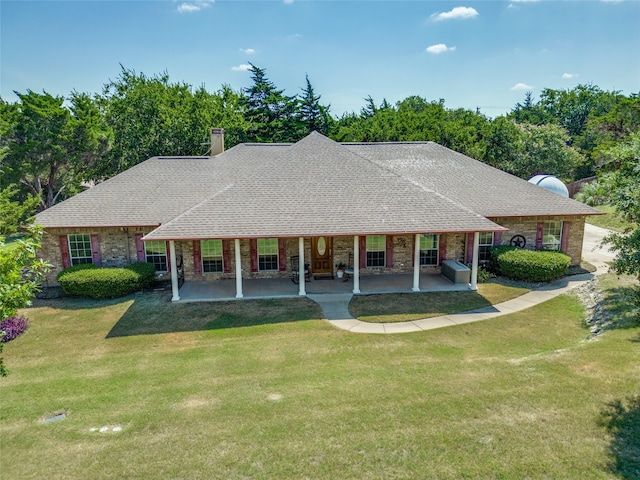 view of front of house with a front yard and a patio area