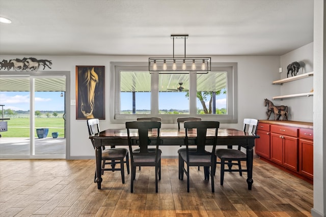 dining space featuring hardwood / wood-style floors, an inviting chandelier, and a wealth of natural light