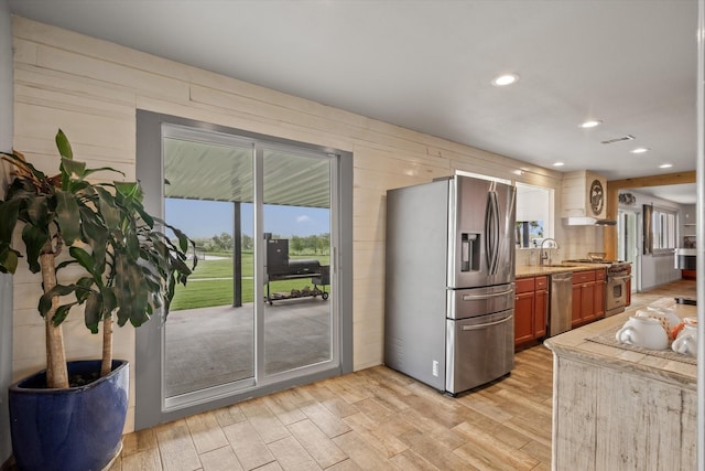 1320 Murrah Ln, Kaufman, TX 75142 - kitchen with stainless steel appliances, light wood finished floors, recessed lighting, wood walls, and light stone countertops