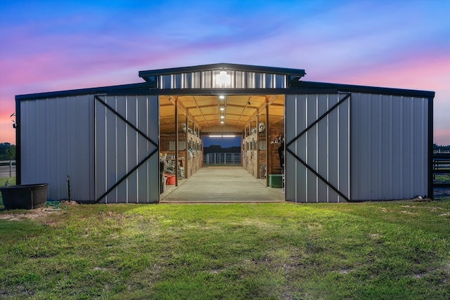 outdoor structure at dusk featuring a lawn