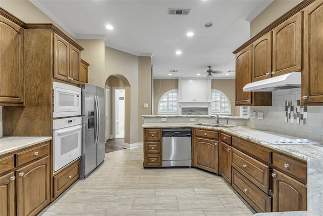 kitchen featuring stainless steel appliances, ornamental molding, sink, kitchen peninsula, and ceiling fan