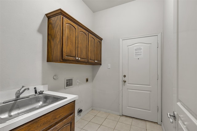 washroom featuring hookup for a washing machine, electric dryer hookup, sink, light tile patterned flooring, and cabinets