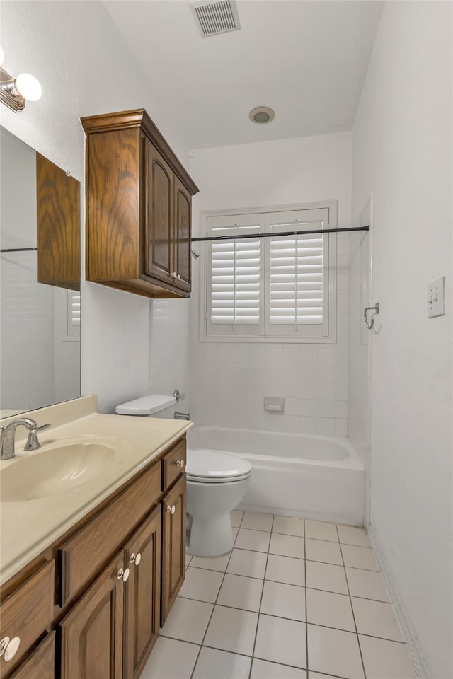 full bathroom featuring tiled shower / bath, vanity, toilet, and tile patterned flooring