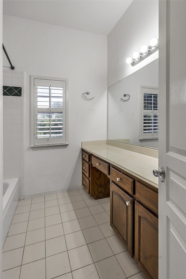 bathroom with tile patterned floors, tiled shower / bath combo, and vanity