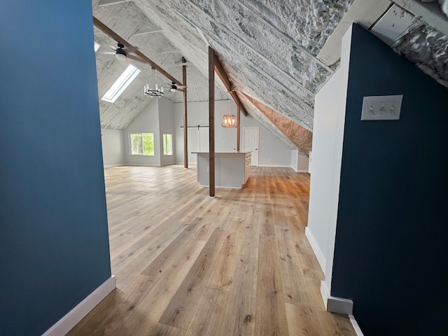 bonus room with ceiling fan, wood-type flooring, and a skylight