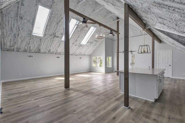 additional living space with a skylight, high vaulted ceiling, and hardwood / wood-style floors