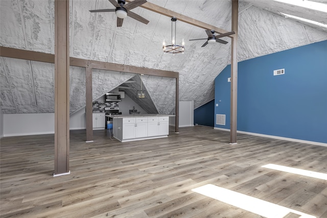 unfurnished living room with high vaulted ceiling, hardwood / wood-style floors, and ceiling fan with notable chandelier