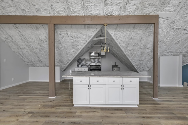 exterior space with white cabinetry, vaulted ceiling, light stone counters, dark wood-type flooring, and appliances with stainless steel finishes