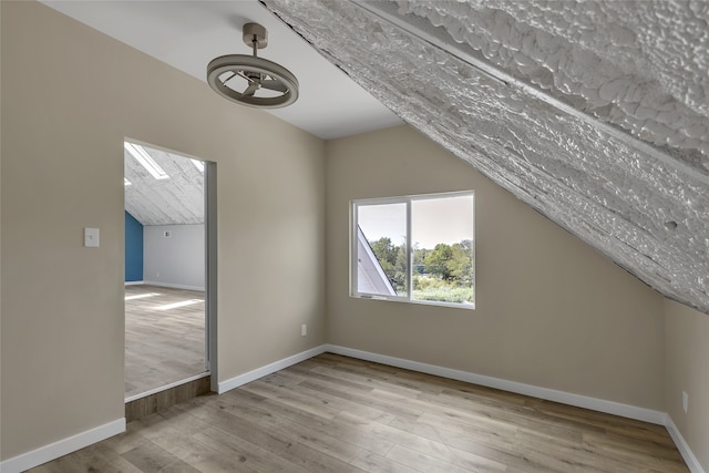 bonus room featuring lofted ceiling and light wood-type flooring