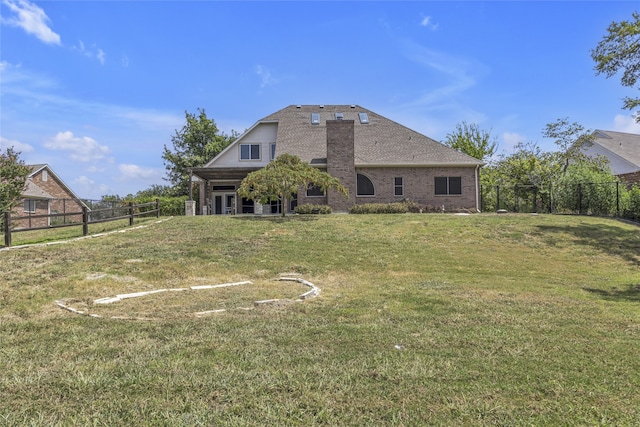 rear view of house featuring a yard