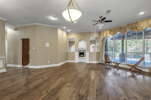 unfurnished living room featuring dark wood-type flooring, ceiling fan, and ornamental molding