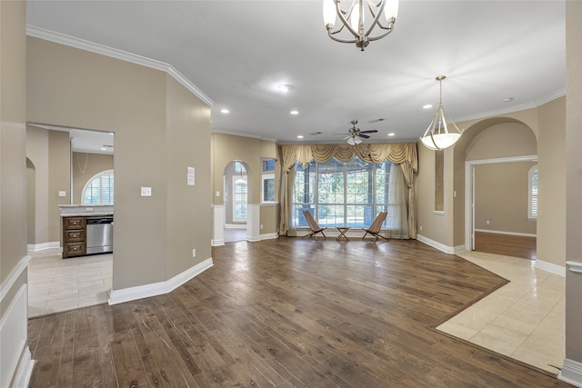 unfurnished living room with light wood-type flooring, ceiling fan with notable chandelier, and ornamental molding