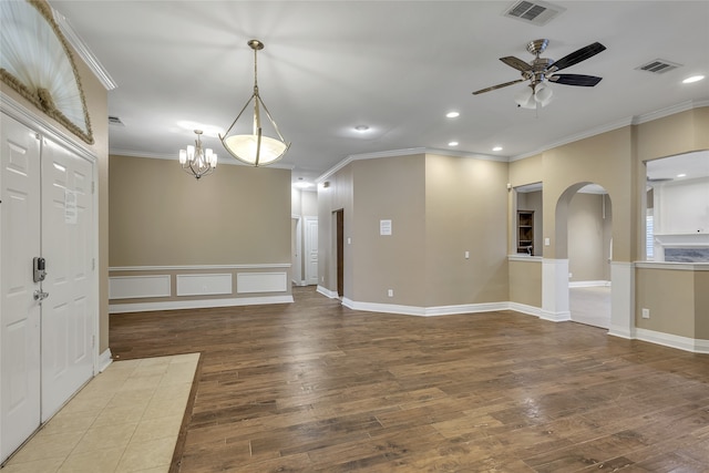 unfurnished room with ceiling fan with notable chandelier, hardwood / wood-style flooring, and ornamental molding