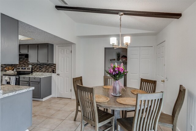 tiled dining room with a textured ceiling, a notable chandelier, and vaulted ceiling