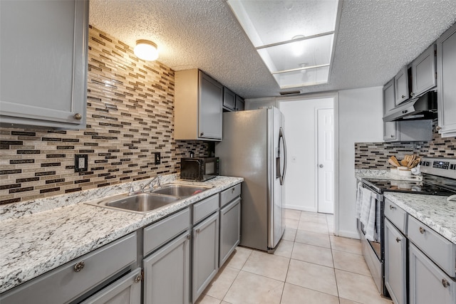 kitchen with gray cabinets, appliances with stainless steel finishes, a textured ceiling, and decorative backsplash