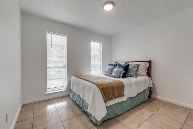 bedroom featuring a textured ceiling and light tile patterned floors