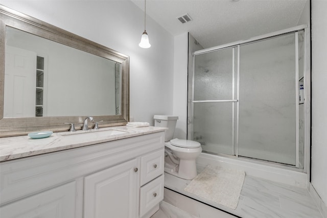 bathroom with a shower with door, vanity, a textured ceiling, and toilet