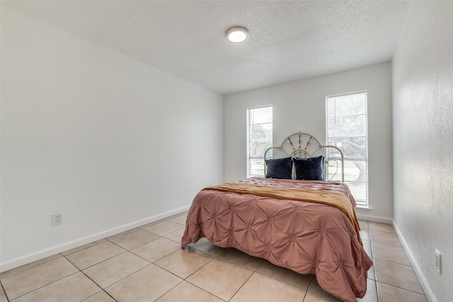 bedroom featuring a textured ceiling and light tile patterned floors