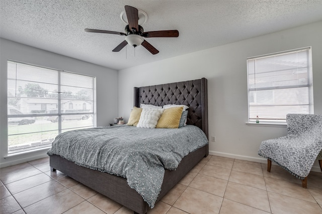 tiled bedroom with a textured ceiling and ceiling fan