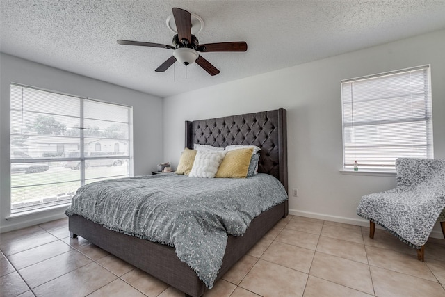 bedroom with ceiling fan, a textured ceiling, and light tile patterned floors