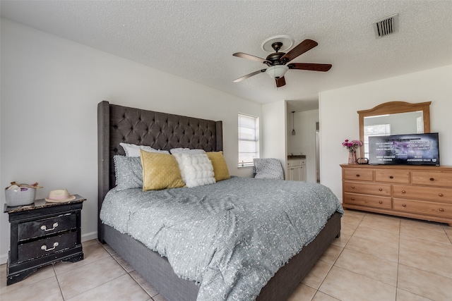 bedroom featuring light tile patterned flooring, a textured ceiling, and ceiling fan