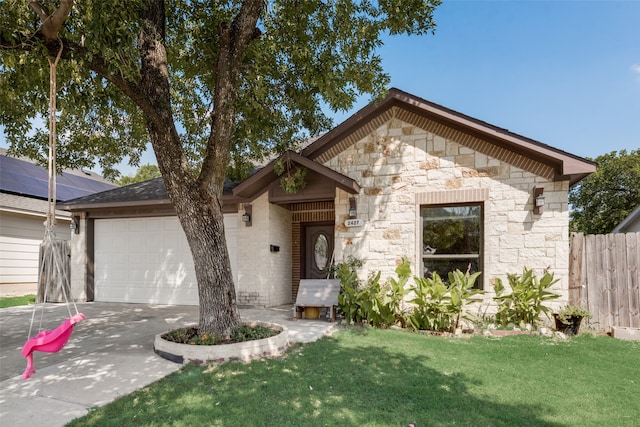 view of front of property with a garage, solar panels, and a front yard