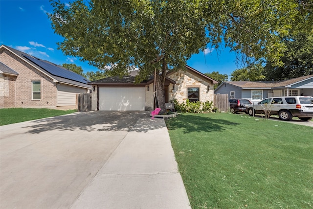 view of front of property featuring a garage, solar panels, and a front yard