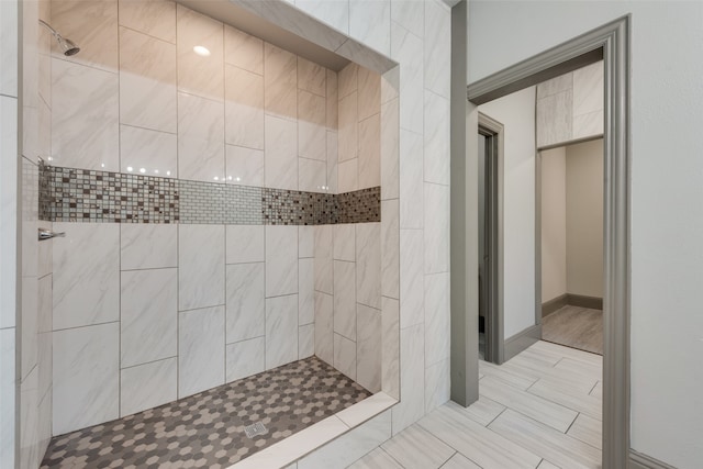 bathroom with tiled shower and tile patterned floors