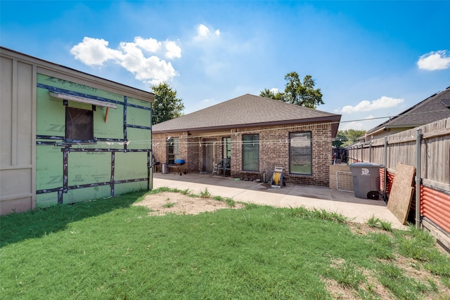 back of property with a yard and a patio