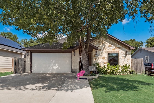 ranch-style house with a garage, solar panels, and a front yard