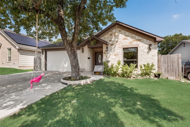 view of front of property featuring a front yard, a garage, and solar panels