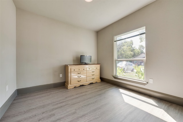 unfurnished room with a healthy amount of sunlight and light hardwood / wood-style flooring