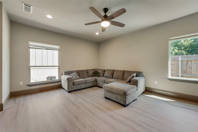 living room with light hardwood / wood-style floors and ceiling fan