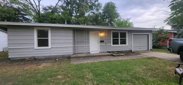 single story home with a garage and a front lawn