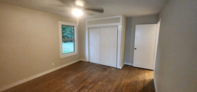 unfurnished bedroom featuring dark hardwood / wood-style floors, ceiling fan, and a closet