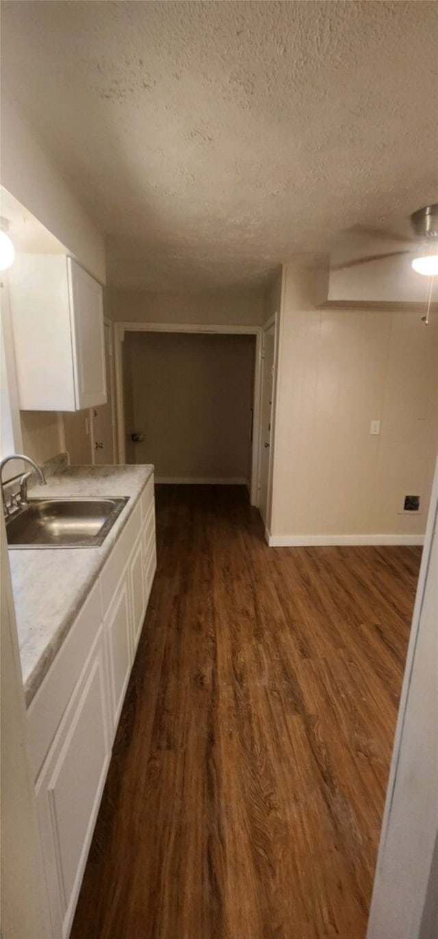 interior space featuring wood-type flooring, sink, and a textured ceiling