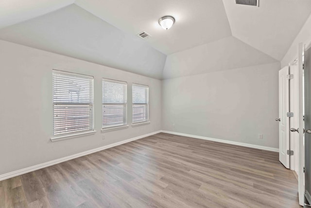 empty room with lofted ceiling and hardwood / wood-style floors