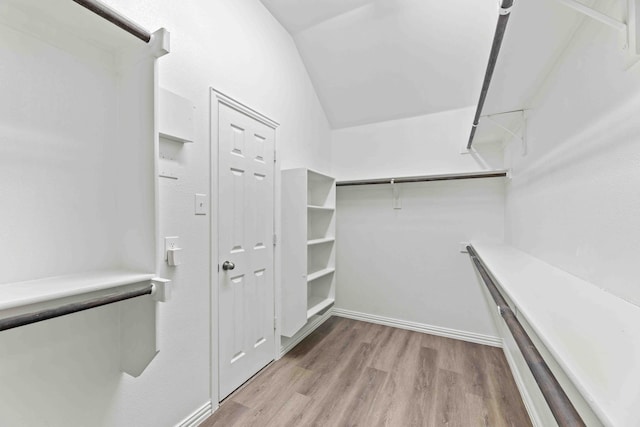 walk in closet featuring vaulted ceiling and light hardwood / wood-style flooring