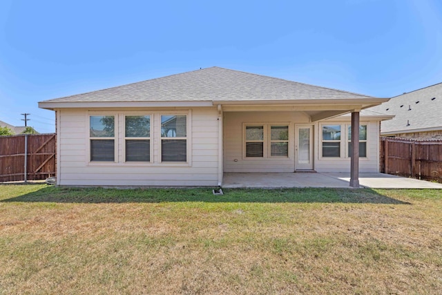 back of property with a yard and a patio