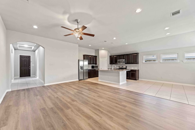 unfurnished living room with sink, light wood-type flooring, and ceiling fan