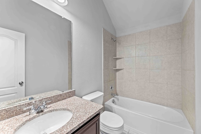 full bathroom featuring tile patterned flooring, lofted ceiling, tiled shower / bath, toilet, and vanity