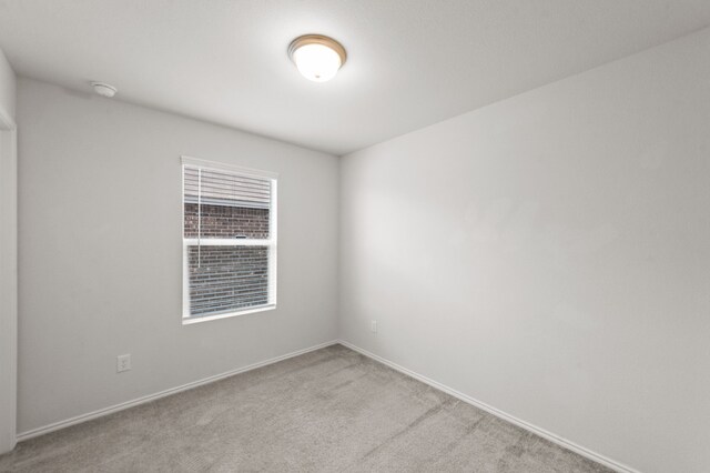 unfurnished room featuring light carpet