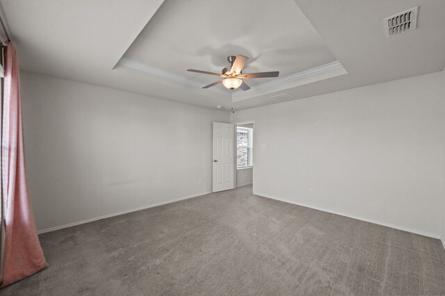 spare room featuring ceiling fan, a tray ceiling, and carpet flooring