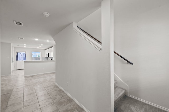 stairway with light tile patterned floors